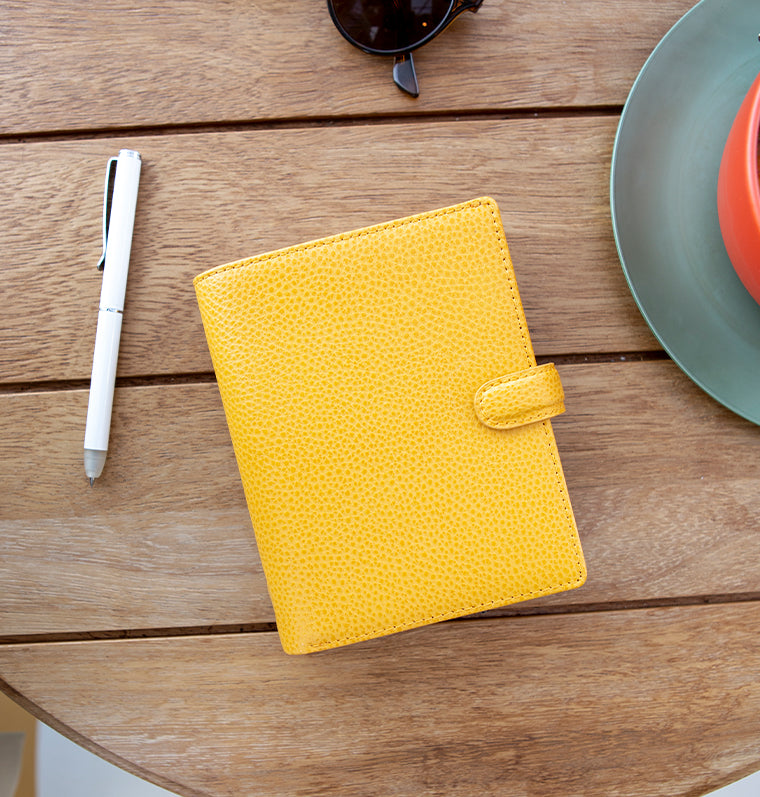 Filofax Finsbury Pocket Leather Organiser in Mustard Yellow on table